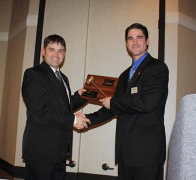 Charly Cummings, the Bid Call Champion for 2009 is presented his plaque by Byron Bina. Charly Cummings, the Bid Call Champion for 2009 is presented his plaque by Byron Bina.